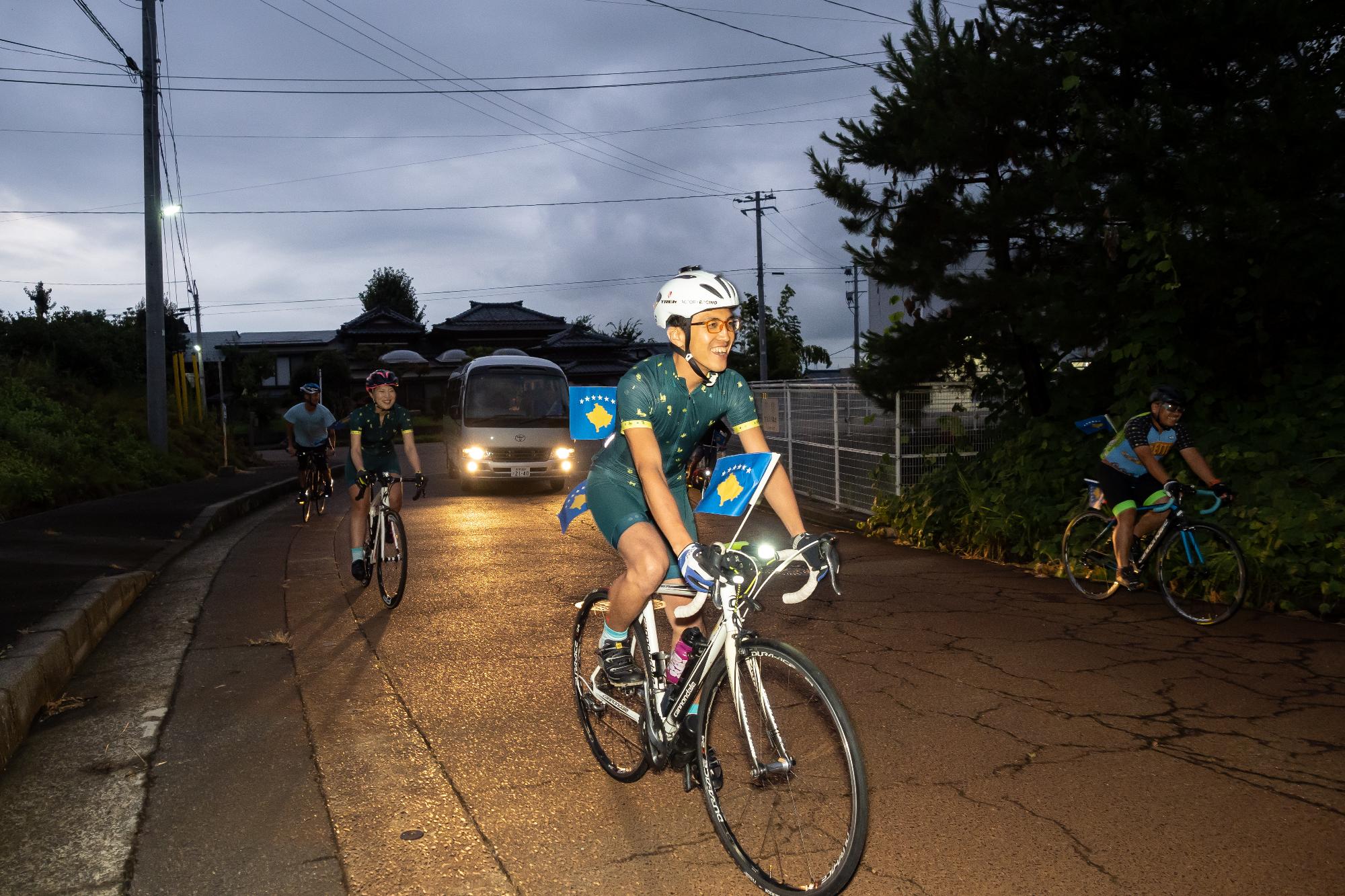 コソボ国旗を付けた自転車による道中先導