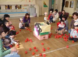 真ん中に箱を置いて子供達で玉入れしている写真