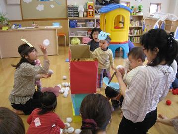 室内で頭にお面をつけて遊んでいる写真