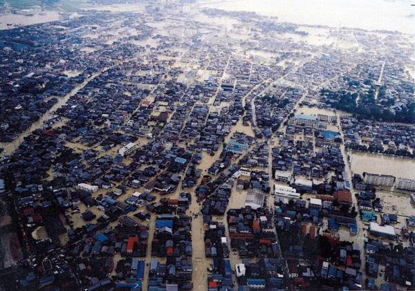道路が黄土色の水で埋め尽くされた被災地の空中写真