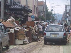 道路脇に浸水し使用できなくなった粗大ごみが積み上げられている北新保一丁目地内の写真