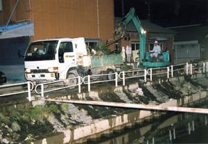 夜間にトラックとショベルカーを使い、24時間体制で被災地のごみを排除している写真