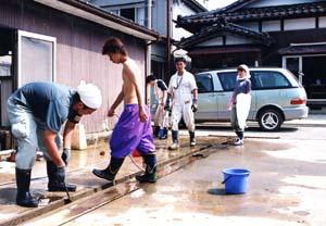 暑さの中、作業を頑張るボランティアの人々の写真