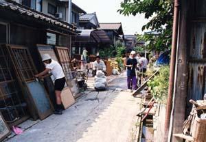 ボランティアの人々がふすまなどを外に出し復旧作業を手伝っている写真