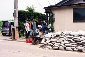 泥出し作業を手伝うボランティアの写真