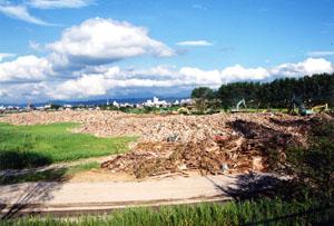 水害ごみが山積みされた旧三条競馬場敷地内の写真