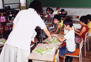 条南小学校全校登校日では、水害でなくした教科書を担任教師から子供達へ配布されている写真