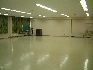 床張りで黒板などがある大集会室の写真