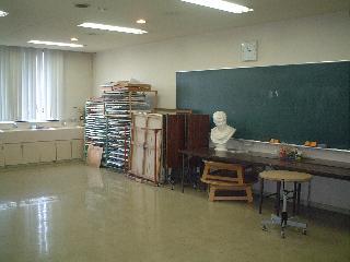 画材置き場、黒板、石膏像などのある床張りの美術実習室の写真