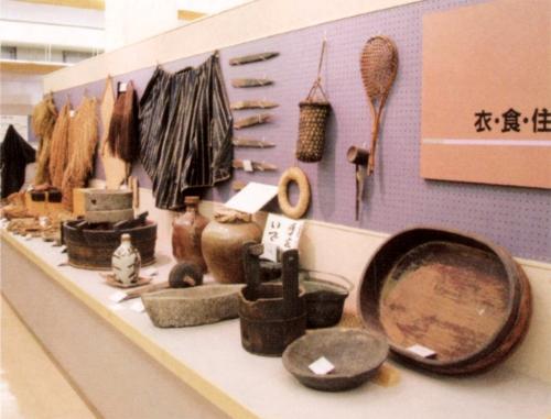 衣食住にかかわる桶、蓑、臼や壺などが展示してある写真
