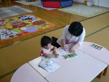 テーブルでお絵かきをしている女性と子供の写真