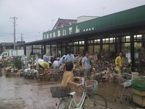 店内に浸水し、売り物にならなくなった商品を店先に出している西四日町地内のスーパーの写真