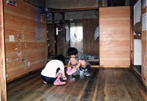 浸水した家の片付けを手伝う子どもたちの写真