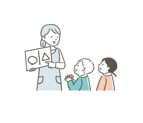 先生が子供二人に本を読んでいる様子